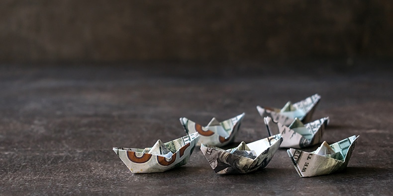 Ships of money on a textured dark background. Many Origami ships from US dollars. The way to big money. Cash, money flow, Financial, Currency economic concept