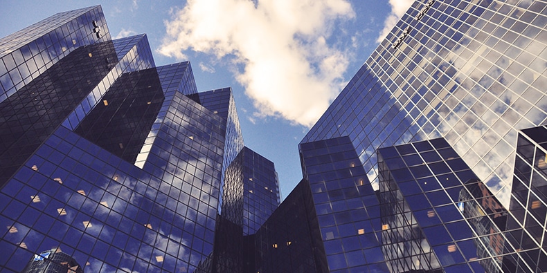 Photo of reflective high-rise office buildings taken from the ground with the sky above