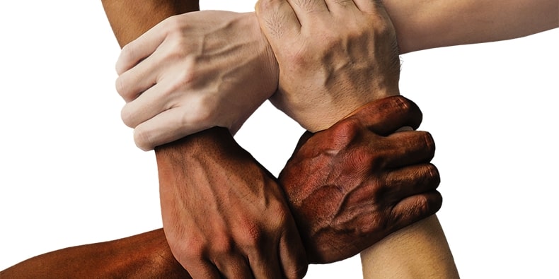 Circle of hands of various races joined together at wrists