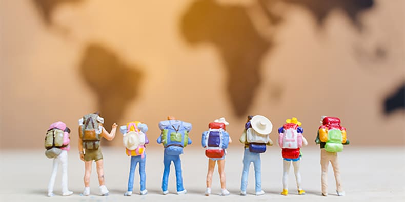 Miniature people travelers walking on world map , Traveling and exploring the world Concept