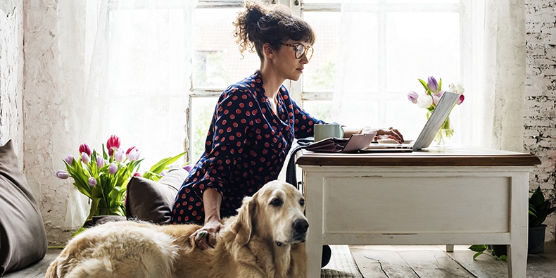 Woman working at home with her dog