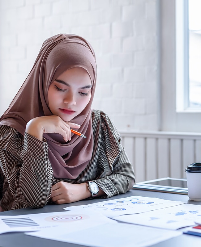 Beautiful modern Arabic business woman brown hijab discussing financial planning data in the creative workplace.
