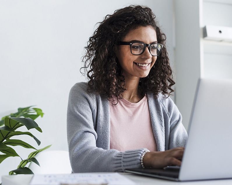 smiling-young-woman-working-laptop-office