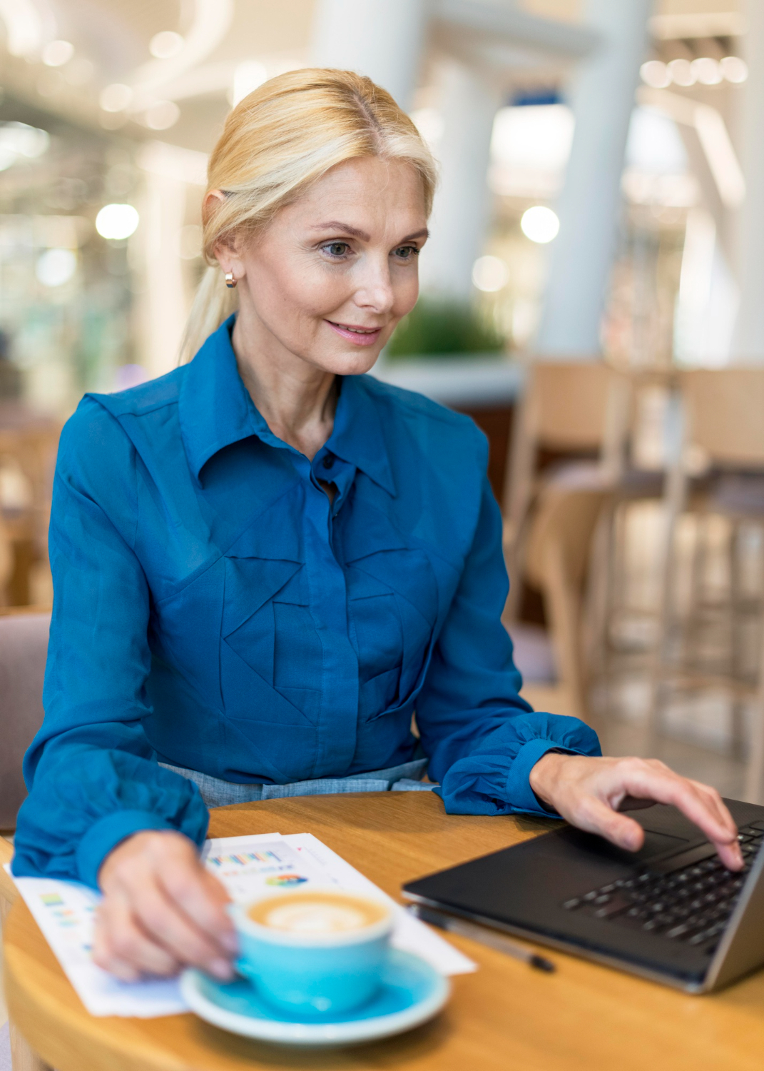 smiley-older-business-woman-working-laptop-having-coffee