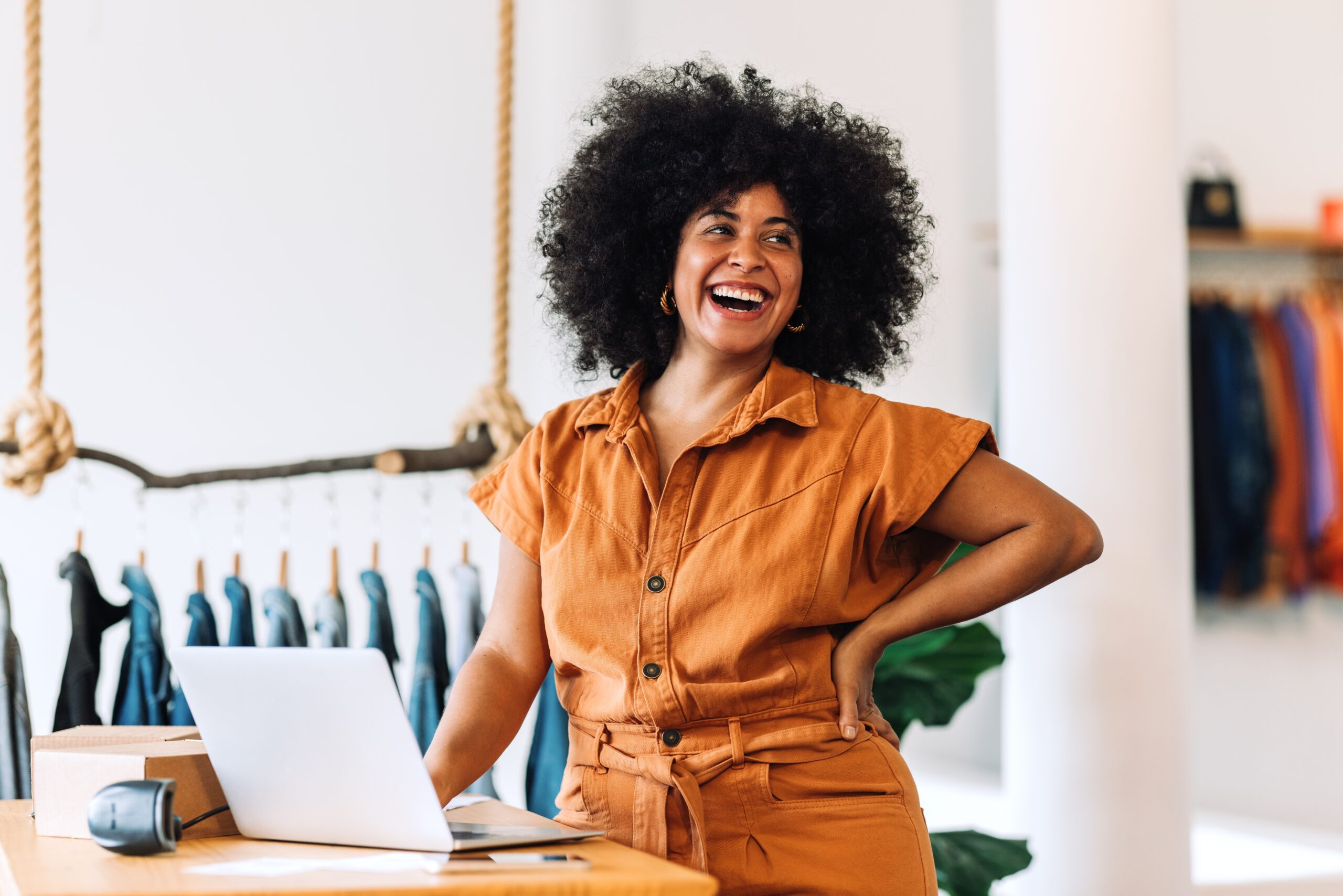 ethnic,small,business,owner,smiling,cheerfully,while,standing,in,her