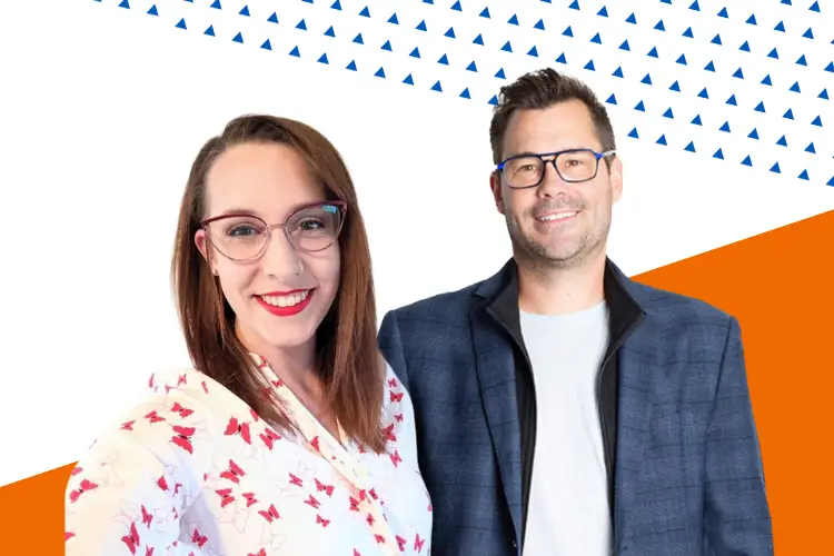 Two smiling presenters standing side by side in front of a geometric background with blue triangles and orange accents. The woman on the left is wearing glasses and a white floral blouse; the man on the right is wearing glasses, a grey shirt, and a blue blazer.