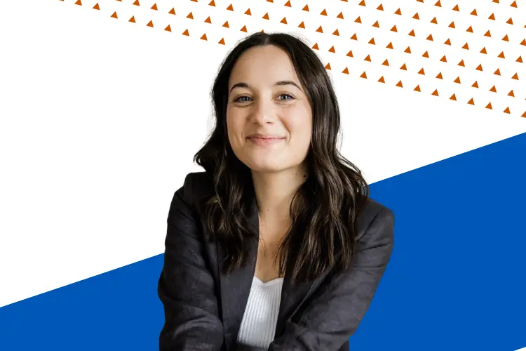 Smiling woman with long dark hair wearing a black blazer and white top, posed against a modern graphic background with blue shapes and orange triangle patterns.