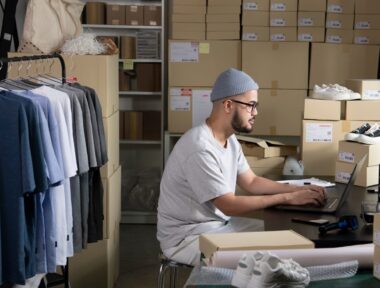 asian,man,online,seller,confirming,orders,from,customer,on,laptop.