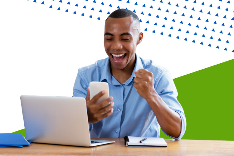 Business professional celebrating success while reviewing information on a laptop and phone, representing winning government contract opportunities.