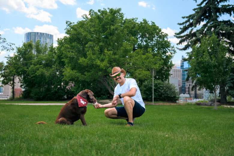 Ritesh Andley feeding a brown dog Pupslurp ice cream