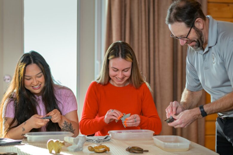 Abigail Caballero and Nicole Onyszkanycz with Michael Emery of Unique Soapstone Experiences during a soapstone carving class.