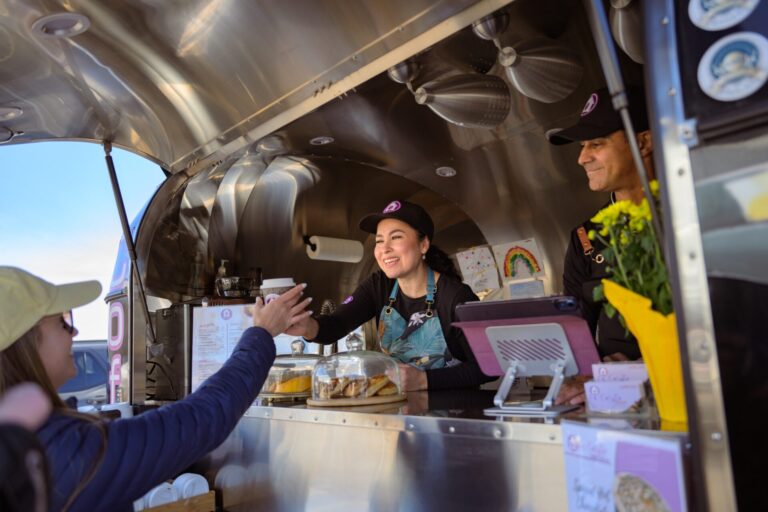 Martha and Luis serving customers from the La Casita mobile coffee cart in Cochrane.