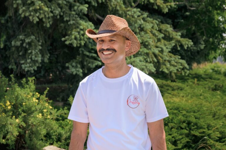Ritesh Andley of PupSlurp wearing a branded shirt in a Calgary park.